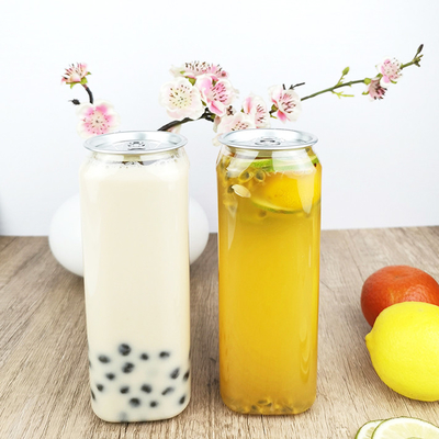 el cuadrado de la categoría alimenticia 0.5L ACARICIA las botellas plásticas con las bebidas de los jugos de las tapas de las latas